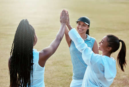 Lets go show them what were made of. a group of young women sharing a high five while out playing tennis.の写真素材