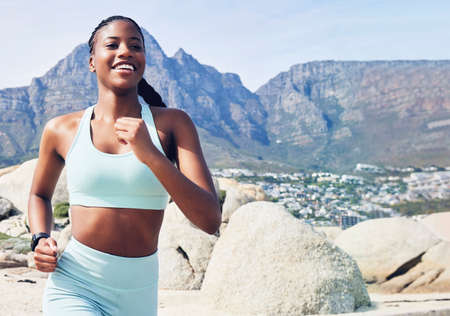 Go for a run, its exhilarating. a fit young woman out for a run along the beach.