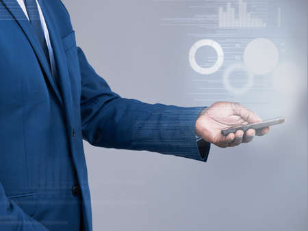 Accessing the world of finance. an unrecognizable businessman using his cellphone to open a virtual...