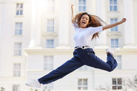 Theres nothing like deep breaths after laughing that hard. a young woman jumping into mid air...