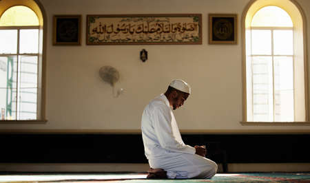 Never underestimate the power of Dua. a young muslim male praying in a mosque.