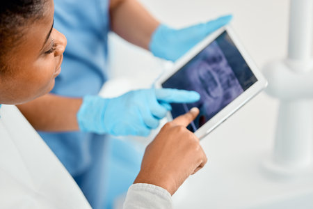 Im so proud of far Ive come. a young woman looking over her dental x-rays with her doctor using a tablet.の写真素材