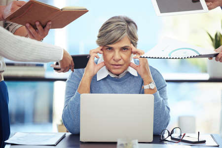 Can this day end. a businesswoman feeling stressed out in a demanding office environment.