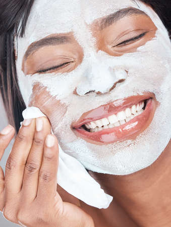 I can almost hear my skin sing. Studio shot of an attractive young woman giving herself a facial.