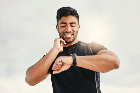 Thats want I want to see. a man using his watch to track his pulse while out for a workout.の写真素材
