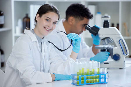 I quite enjoy all the experiments that we do. Portrait of a young woman working in a lab with her...