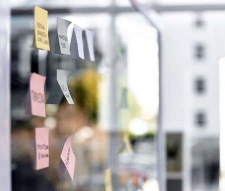 Turning ideas into profitable results. Closeup shot of sticky notes on a glass screen in an empty office.の写真素材