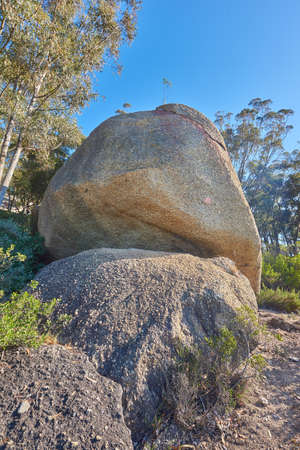 Blue sky, weathered rock and cracked stone from heat exposure and wind erosion along a countryside...