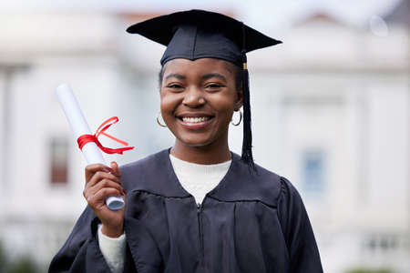 My next chapter will be just as great. Portrait of a young woman holding her diploma on graduation day.の写真素材