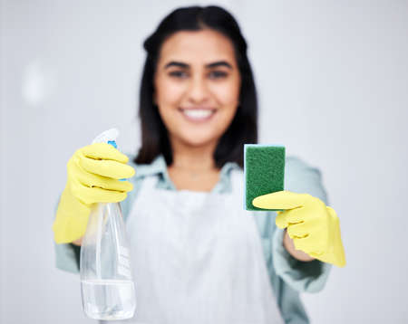 Lets make this place brand new again. Closeup shot of a woman holding up a spray bottle and sponge.