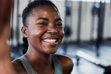 Going to the gym is the best drug. a fit young woman laughing while taking a selfie at gym.