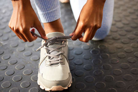 All it takes is a step in the right direction. an unrecognizable woman tying her shoelaces before a...