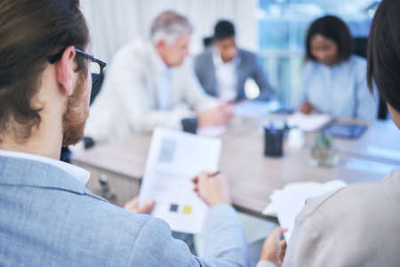 We have some good news to share with our team. two people looking at a document while in the boardroom.の写真素材