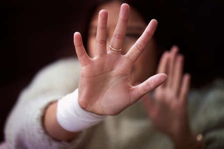 Stay away from me. a young woman looking distressed and reading out her hand.の写真素材