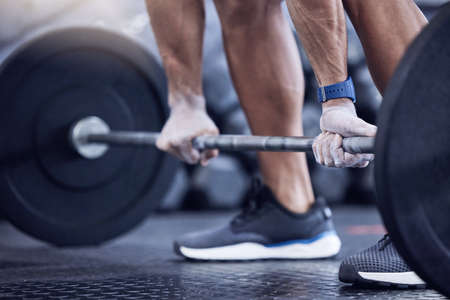 One more lift for the road. an unrecognisable man working out with a barbell at the gym.の写真素材