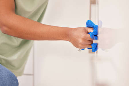 Scrubbing my way to a sparkly clean. a man cleaning a wall with a cloth.の写真素材