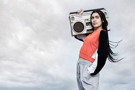 To dance is my passion. Cropped portrait of an attractive young female dancer standing with her boombox against a stormy backdrop.の写真素材