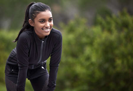Im excited to keep going. a sporty young woman taking a break while exercising outdoors.の写真素材