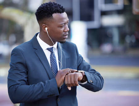 I should be there in time. a young businessman standing in the street in the city.