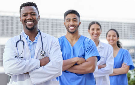 Theyre ready to be your healthcare heroes. a group of doctors standing against a city background.の写真素材