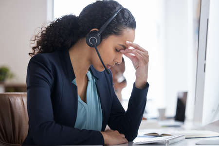 Whos there to help me. an attractive young female call center agent looking stressed while working at her desk in the office.の写真素材