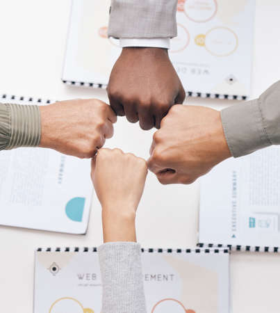 A great team supports each other. a group of unrecognizable businesspeople giving each other a fist...