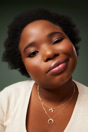 You know what Im sayin. an attractive young woman pulling a funny face while posing against a green...