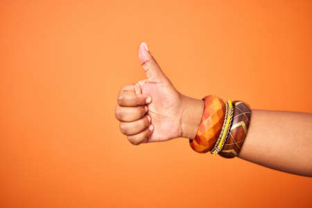 Youre doing a great job. an unrecognizable person showing a thumbs up against an orange background.の写真素材