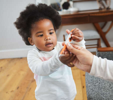 an unrecognizable mother checking her daughters temperature at home.の写真素材