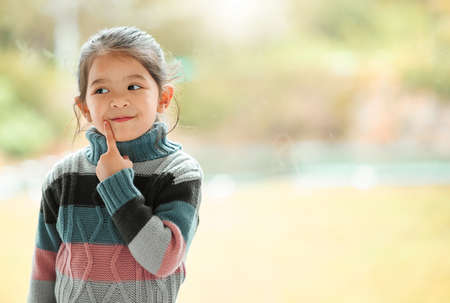 I know where mom hides the snacks. an adorable little girl at home.の写真素材