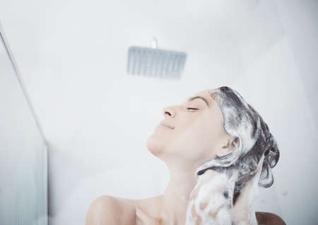 Lathering the day away. a woman washing her hair in the shower.