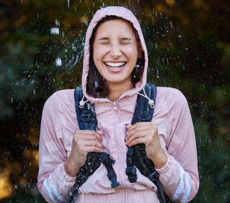 All you need sometimes is to stand in the rain. an attractive young woman standing alone outside in...