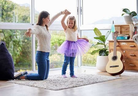 Show her how a princess should be treated. a young mother and daughter practicing ballet at home.の写真素材