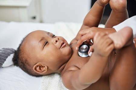 Youre such a cutie pie. a doctor listening to a babys chest using a stethoscope.