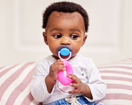 Finally some alone time. a little baby girl playing with her toy to entertain herself.