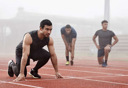 Ready to leave you all in the dust. a male athlete ready to begin a race.
