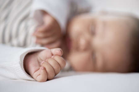 Babies need lots of sleep to grow. Closeup shot of a babys hand while asleep at home.の写真素材