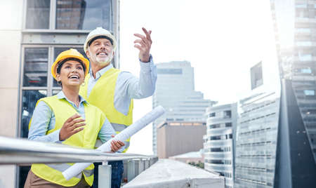 Monitoring their build. two businesspeople working together at a construction site.