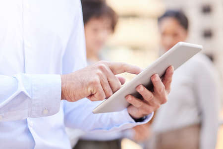 Moving some appointments around. an unrecognisable businessman standing outside and using a digital...