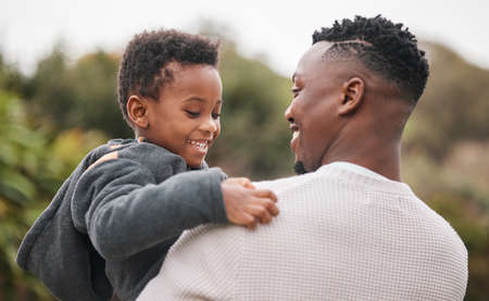 Are you happy I brought you out to the park today. an adorable little boy being carried by his father while bonding together outdoors.の写真素材
