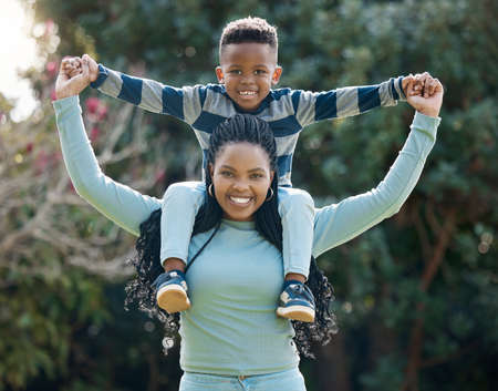 Mum makes me feel brave. a young mother bonding with her son and giving him a piggyback ride in the garden.の写真素材