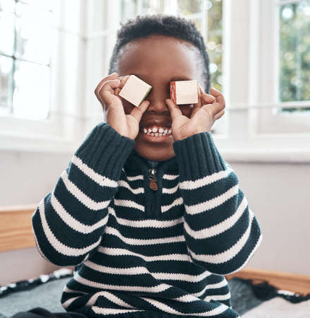 Theres more where these came from. a little boy playing with wooden blocks at home.