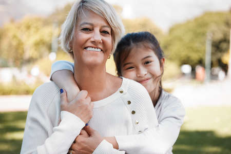 I will move heaven and earth for my grandchild. Portrait of a little girl bonding with her grandmother outdoors.の写真素材