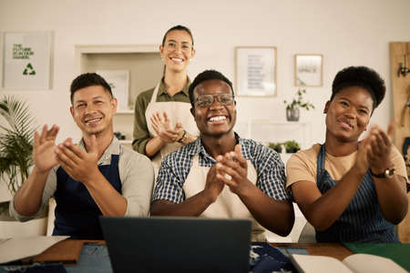 Clapping, cheering and excited fashion design team welcoming, celebrating and supporting employee...