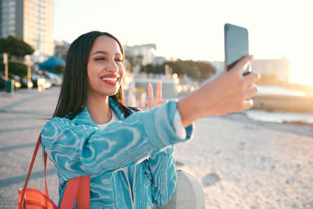 Fun, happy and trendy student taking a selfie on phone for social media while exploring, visiting...