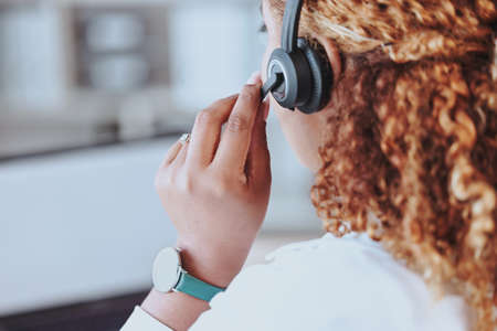 Talking, advice, discussion being had by a call center agent wearing a headset in an office at work. Customer service, support and conversation given to a client from a female working at a startupの写真素材