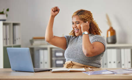 Excited, happy and celebrating business woman cheering for success while working on a laptop in her...
