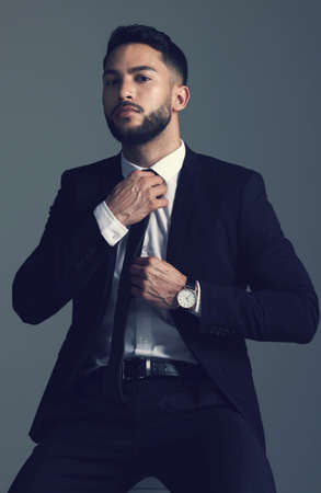 Getting ready for a big night. Studio shot of a young man posing against a grey background.の写真素材