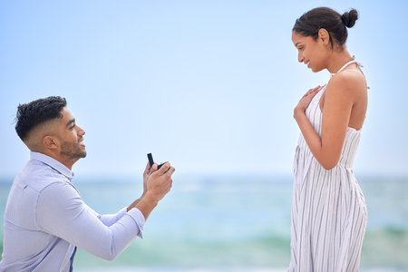 I knew you were the one from the moment we met. a young man proposing to his girlfriend on the beach.の写真素材