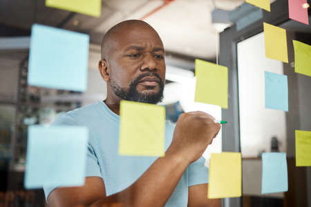 An hour of planning can save you 10 hours of doing. a businesswoman brainstorming with sticky notes...